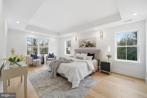 a bedroom with a bed and large windows