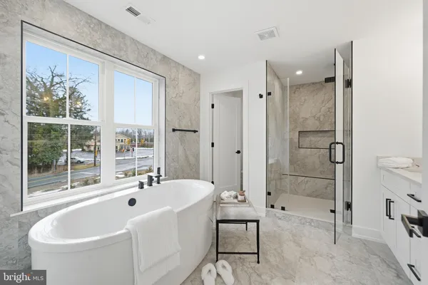 a spacious bathroom with a tub shower and mirror