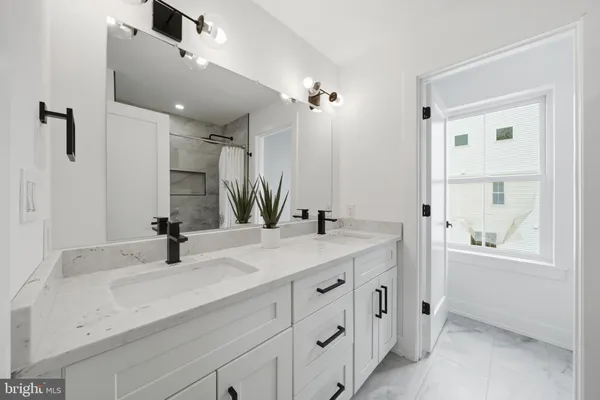 a bathroom with a double vanity sink mirror and bathtub