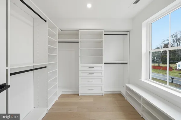 a view of walk in closet with empty racks