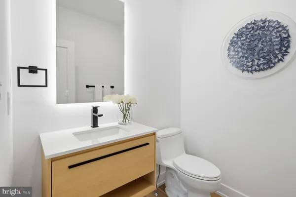 a bathroom with a toilet a sink and mirror