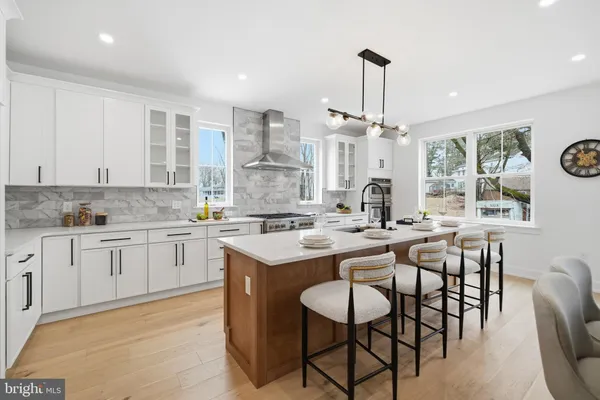 a kitchen with a dining table chairs sink and white cabinets