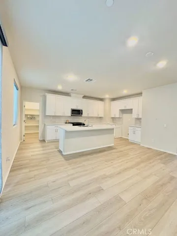 a view of kitchen with granite countertop white cabinets and refrigerator
