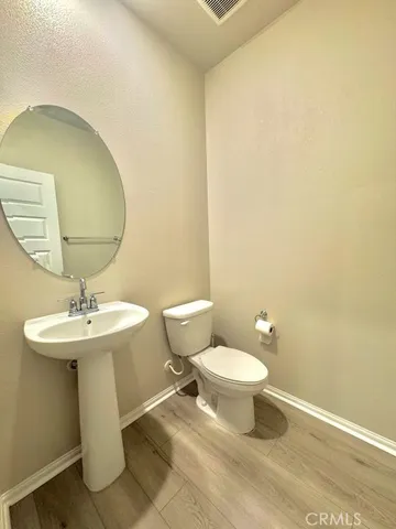 a bathroom with a sink a toilet and mirror