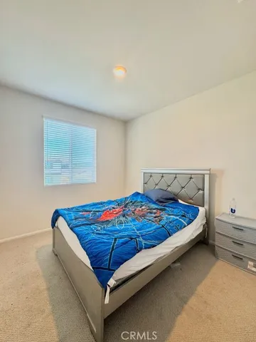 a bed sitting in a bedroom next to a window