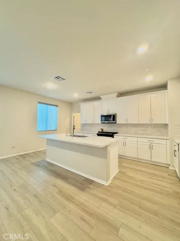 a view of kitchen with stainless steel appliances cabinets and wooden floor