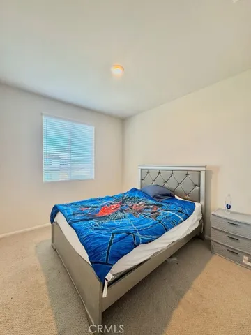 a bed sitting in a bedroom next to a window