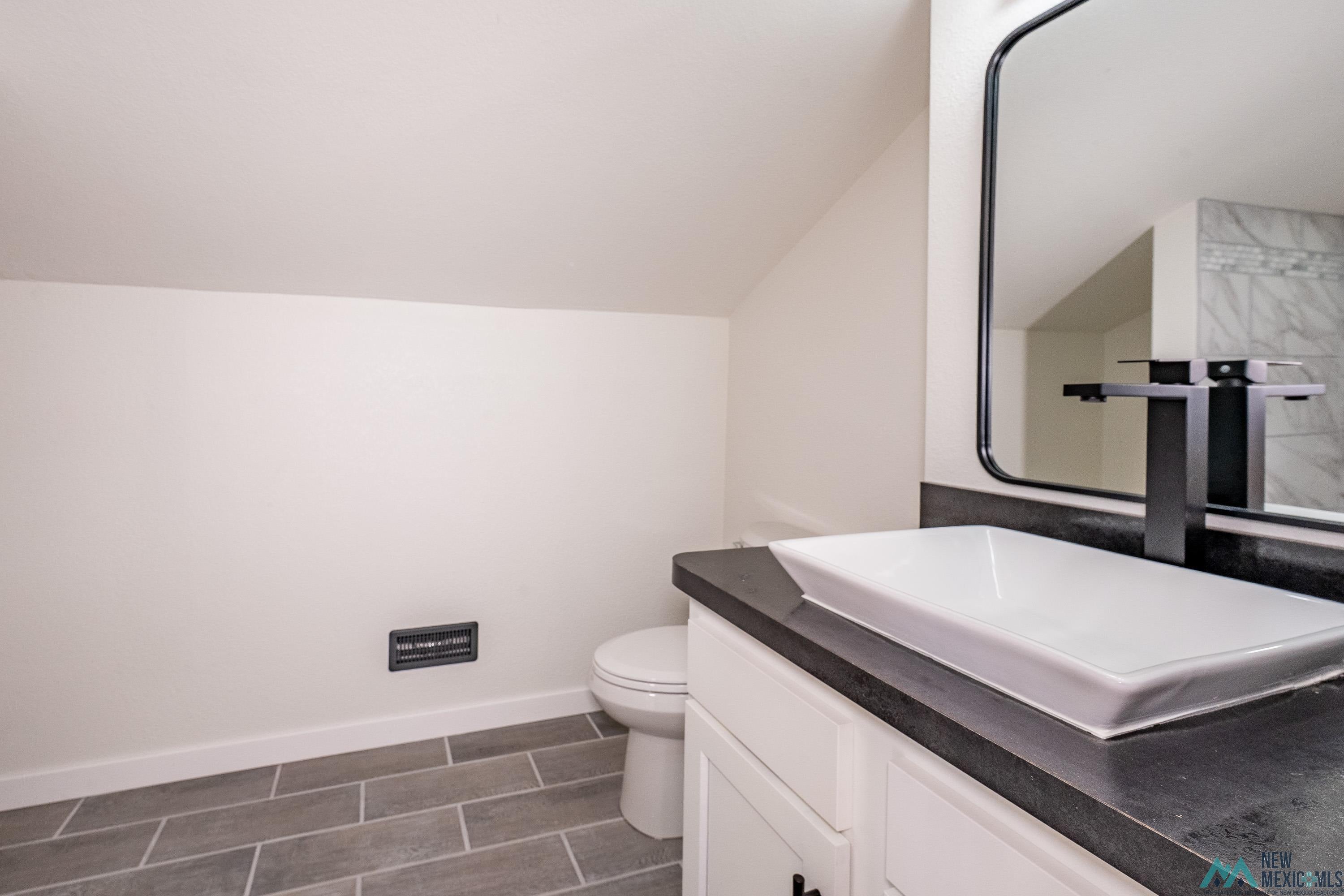 1131 Lincoln Avenue Raton, NM 87740 - Photo 26 of 41 Half bathroom with vanity and lofted ceiling