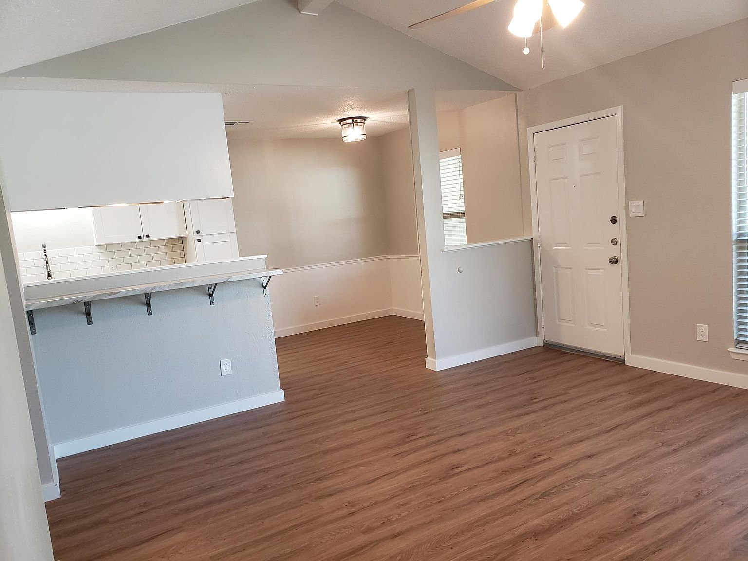 802 Ranch Road, Unit A Georgetown, TX 78628 - Photo 3 of 11 Laminate flooring connects an inviting living space to a functional kitchen and dining area.