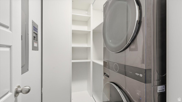 2038 East Ranch Road Eagle Mountain, UT 84005 - Photo 25 of 66 Dedicated utility area featuring a stacked washer and dryer unit, integrated shelving, and white wall finishes
