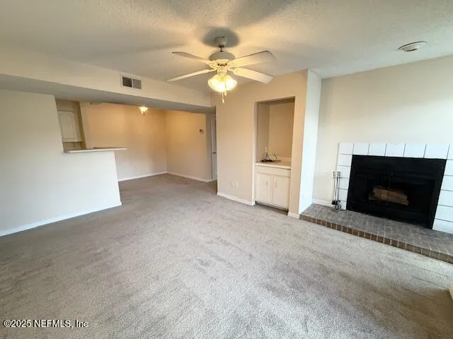 an empty room with a fireplace and a chandelier fan