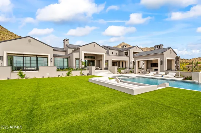 a front view of a house with swimming pool having outdoor seating