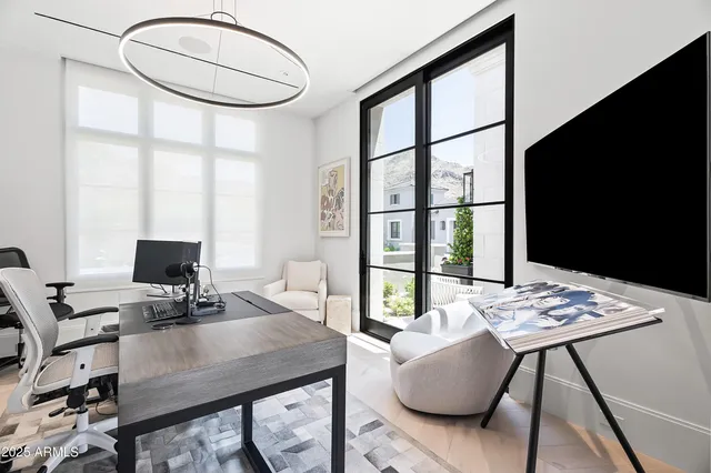 a view of a workspace with furniture and a window