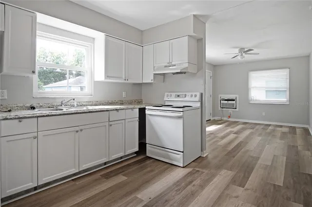 a kitchen with granite countertop white cabinets and white appliances