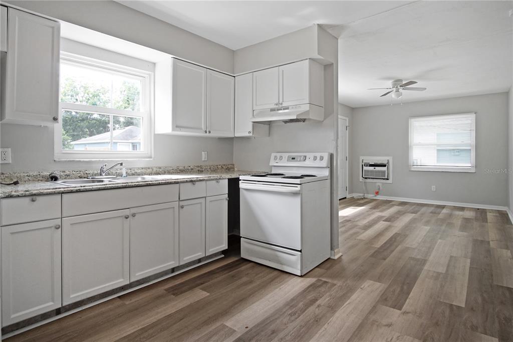 1480 32nd Street Northwest Winter Haven, FL 33881 - Photo 5 of 13 a kitchen with granite countertop white cabinets and white appliances