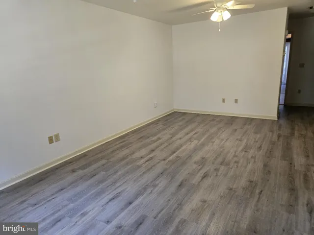 a view of a room with wooden floor and white walls