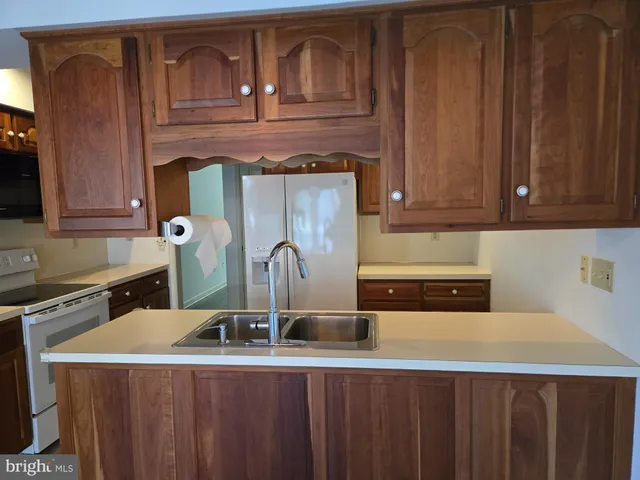 a kitchen with a sink a stove and cabinets