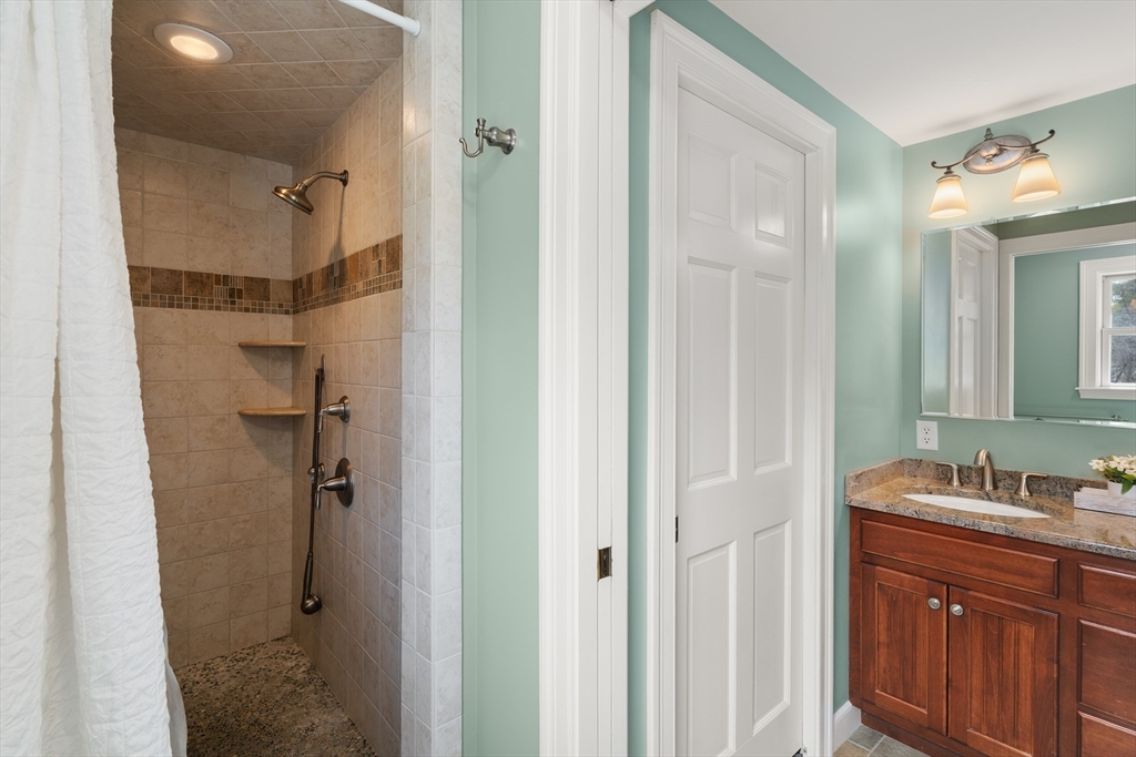 23 Alta Road Sudbury, MA 01776 - Photo 19 of 38 a bathroom with a shower sink and mirror
