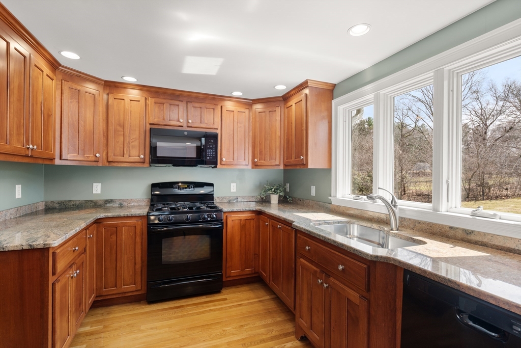 23 Alta Road Sudbury, MA 01776 - Photo 9 of 38 a kitchen with stainless steel appliances granite countertop a stove a sink and a microwave