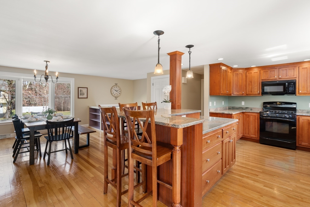 23 Alta Road Sudbury, MA 01776 - Photo 10 of 38 a open kitchen with stainless steel appliances kitchen island granite countertop a stove a sink a dining table and chairs with wooden floor