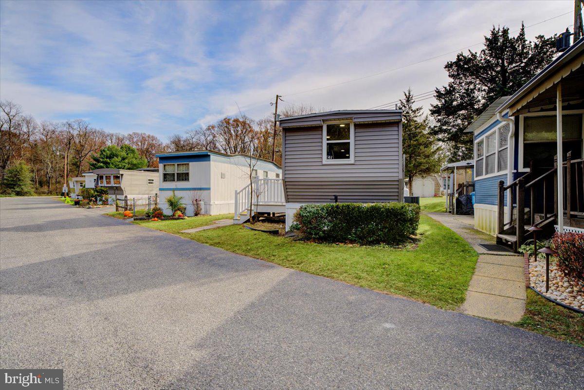 114 Cookstown New Egypt Road Wrightstown, NJ 08562 - Photo 3 of 30 a view of a white house with a yard and table and chairs under an umbrella