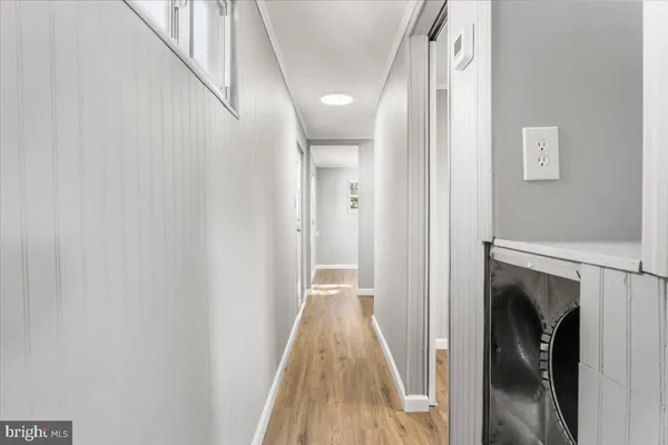 a view of a hallway with wooden floor and staircase
