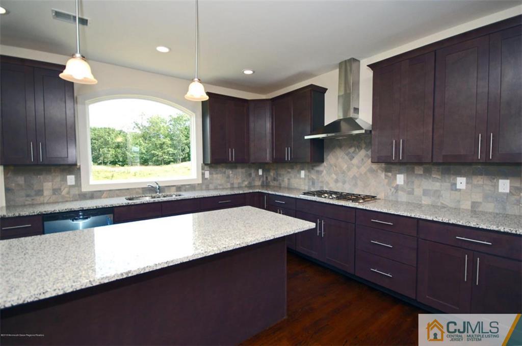 4 Beacon Hill Millstone Township, NJ 08510 - Photo 9 of 19 a kitchen with granite countertop a sink a stove and a microwave oven on cabinets