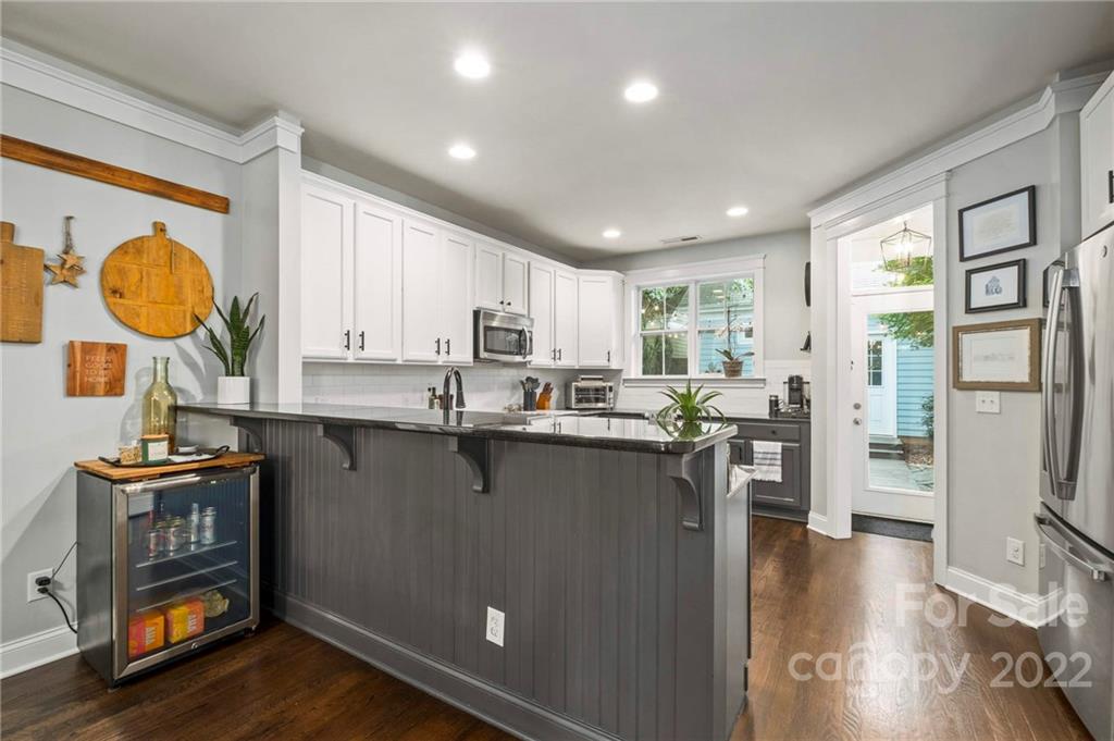 489 Jetton Street Davidson, NC 28036 - Photo 13 of 33 a kitchen with granite countertop a refrigerator a stove a sink a dining table and chairs with wooden floor
