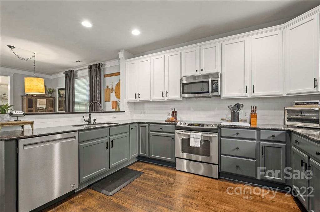 489 Jetton Street Davidson, NC 28036 - Photo 15 of 33 a kitchen with stainless steel appliances granite countertop a stove and a sink