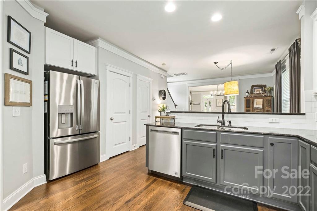 489 Jetton Street Davidson, NC 28036 - Photo 16 of 33 a kitchen with stainless steel appliances granite countertop a refrigerator a sink dishwasher a stove and white cabinets with wooden floor