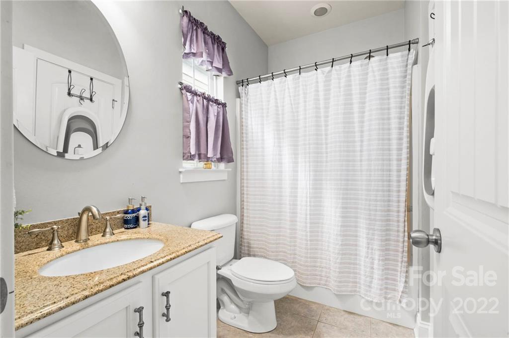 489 Jetton Street Davidson, NC 28036 - Photo 23 of 33 a bathroom with a granite countertop sink mirror vanity and toilet