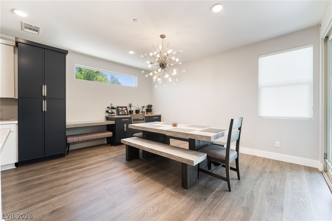 2166 Trivero Street Henderson, NV 89044 - Photo 11 of 61 A striking sputnik chandelier illuminates this dining area with wood flooring and natural light.