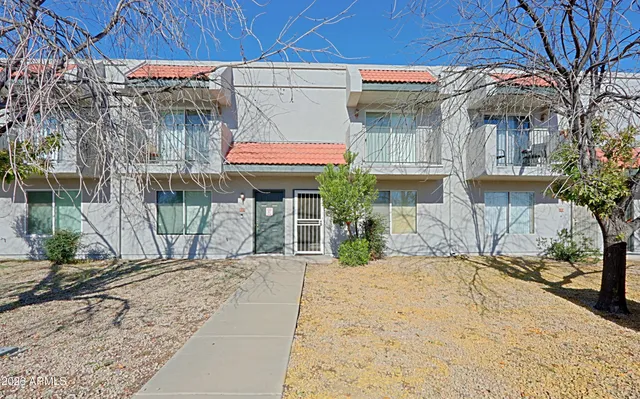 a patio with a table and chairs under an umbrella
