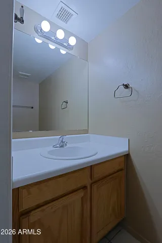 a bathroom with a granite countertop sink a light fixture and a mirror