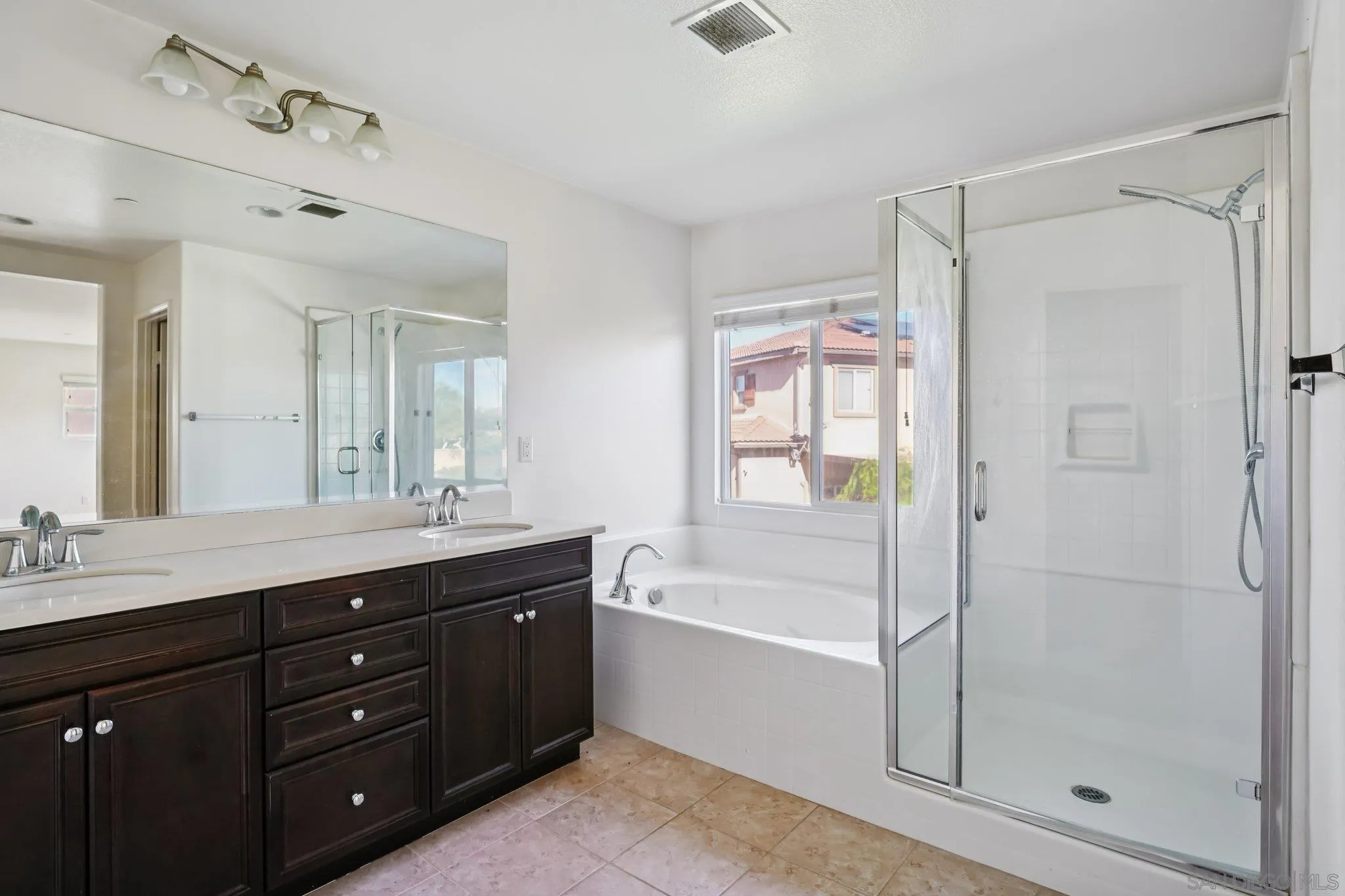 31890 Rouge Lane Menifee, CA 92584 - Photo 31 of 40 a spacious bathroom with a granite countertop sink a mirror a bathtub and shower