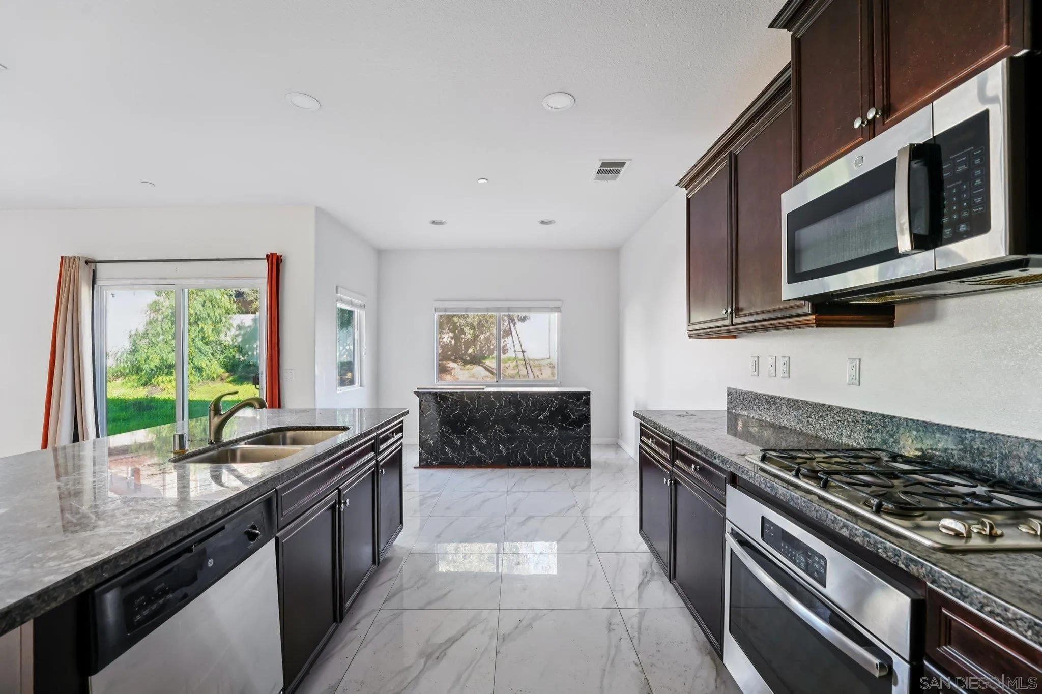 31890 Rouge Lane Menifee, CA 92584 - Photo 5 of 40 a kitchen with stainless steel appliances granite countertop a stove a sink and a microwave