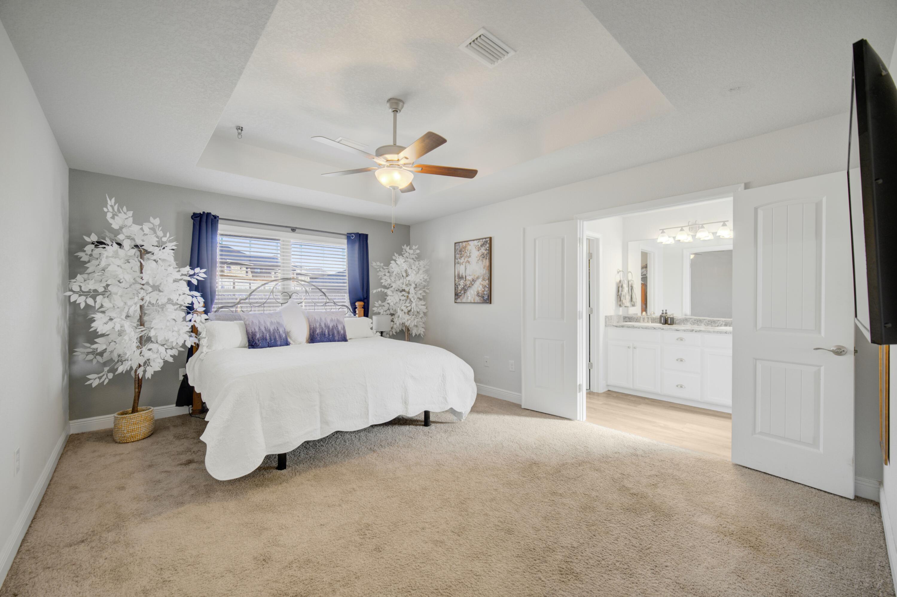 2045 Broad Street Crestview, FL 32536 - Photo 14 of 36 a spacious bedroom with a large bed and a chandelier