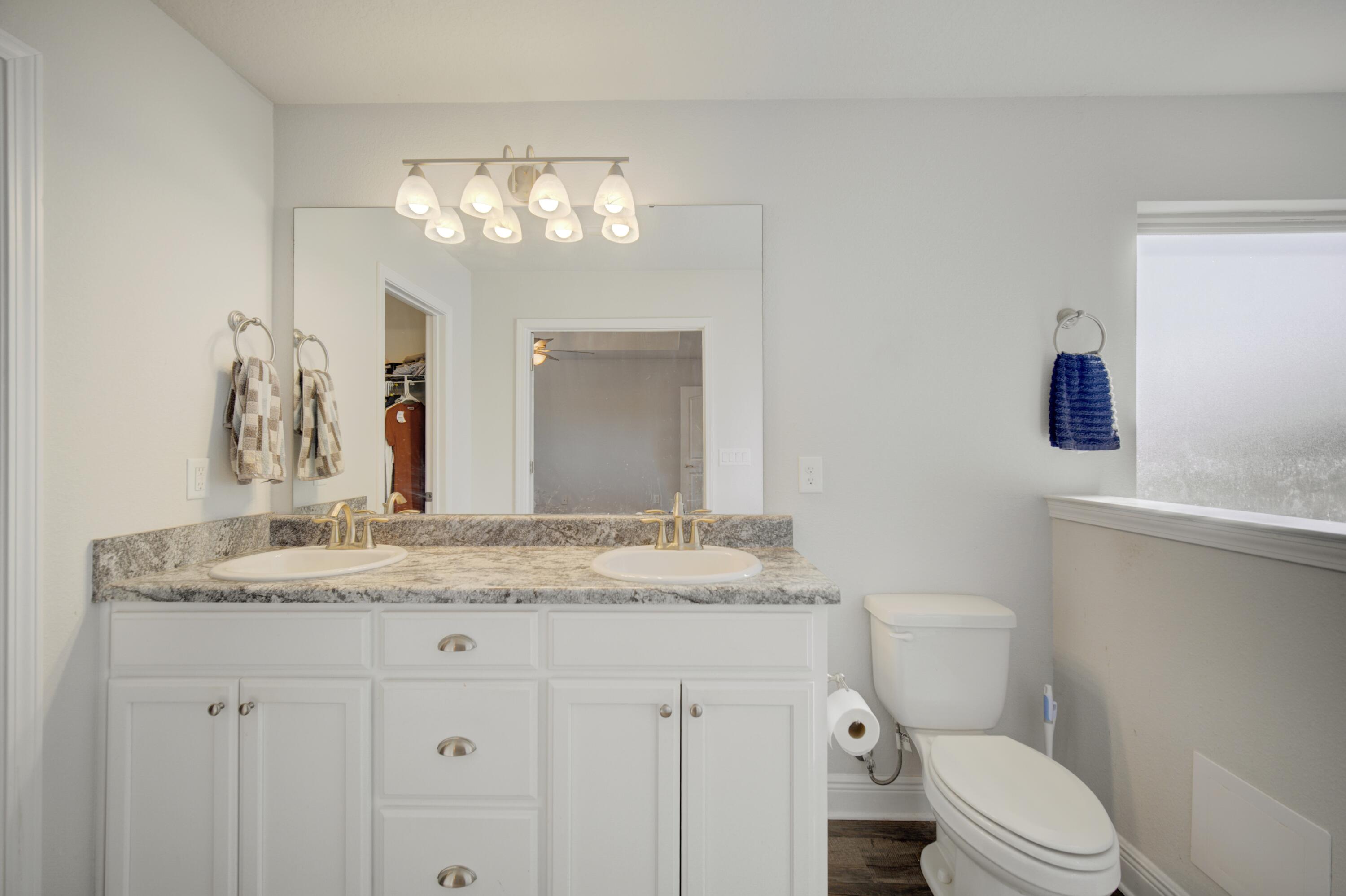 2045 Broad Street Crestview, FL 32536 - Photo 17 of 36 a bathroom with a granite countertop sink vanity mirror and toilet