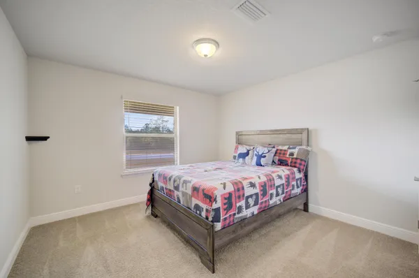 a bed sitting in a bedroom next to a window