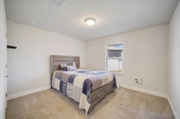 a bed sitting in a bedroom next to a window