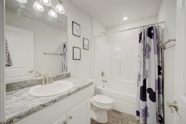 a bathroom with a granite countertop sink toilet and shower