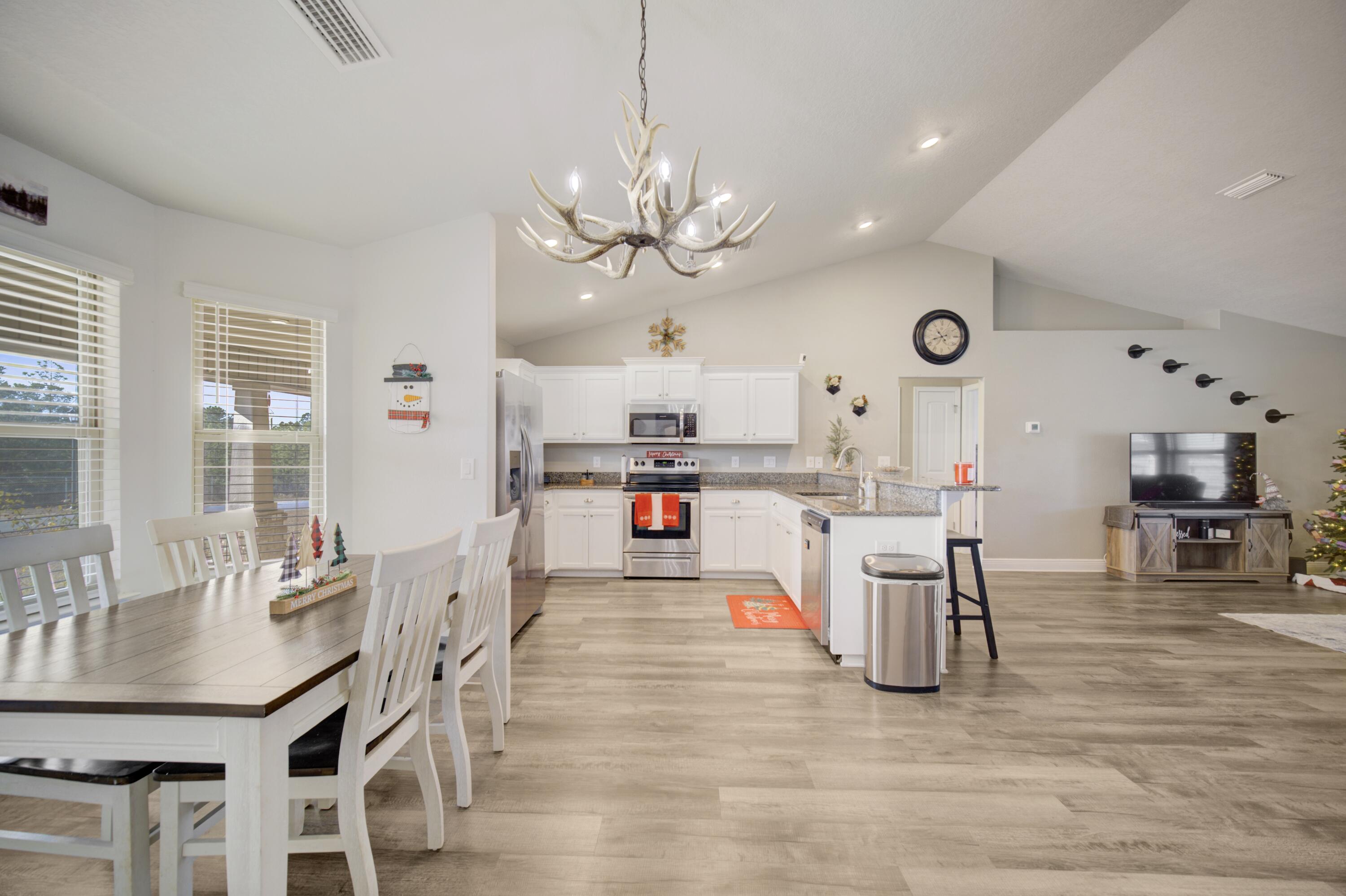 2045 Broad Street Crestview, FL 32536 - Photo 10 of 36 a kitchen with stainless steel appliances kitchen island granite countertop a table chairs and a refrigerator