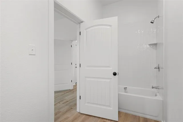 a view of empty room with wooden floor and fireplace