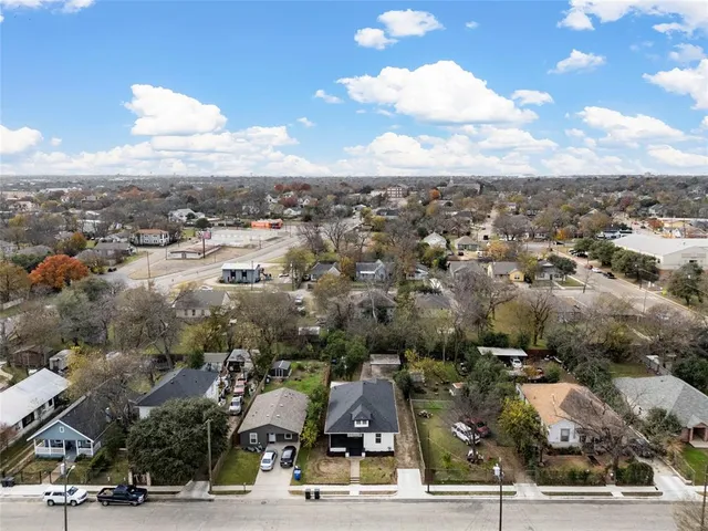 a front view of a house with potted plants and wooden floor