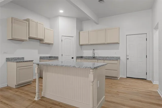 a kitchen with stainless steel appliances granite countertop a stove a sink and white cabinets