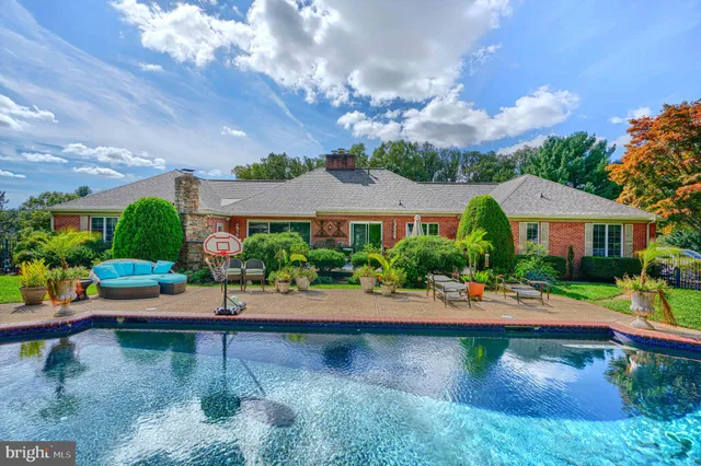 a view of backyard with swimming pool and outdoor seating