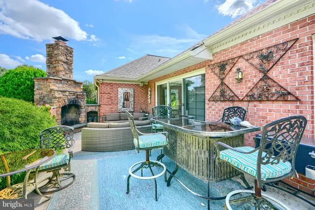 a living room with furniture a fireplace and floor to ceiling windows
