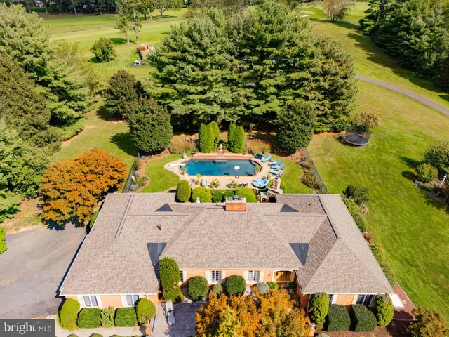 an aerial view of a house with a yard swimming pool a patio and lake view