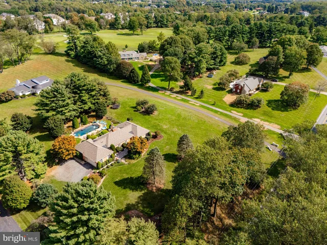 an aerial view of residential houses with outdoor space and swimming pool