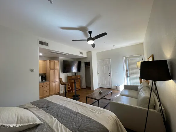 a bedroom with bed tv and window